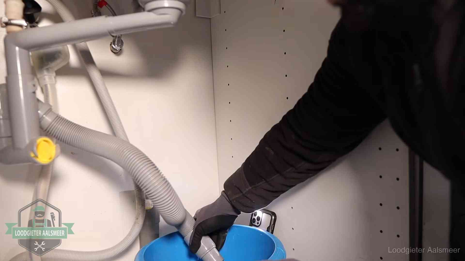 Afvoerslang loopt leeg in een emmer onder de gootsteen in Aalsmeer, een klus die je zelf kunt doen