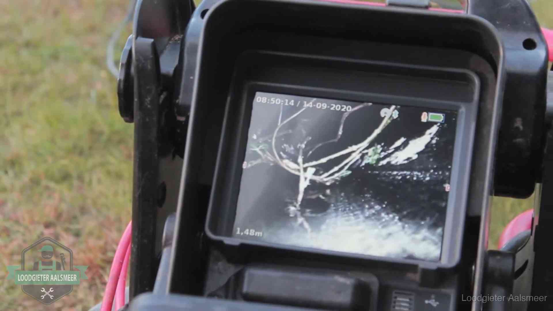 Monitor van een rioolcamera toont wortelingroei in de rioolbuis bij een woning in Aalsmeer