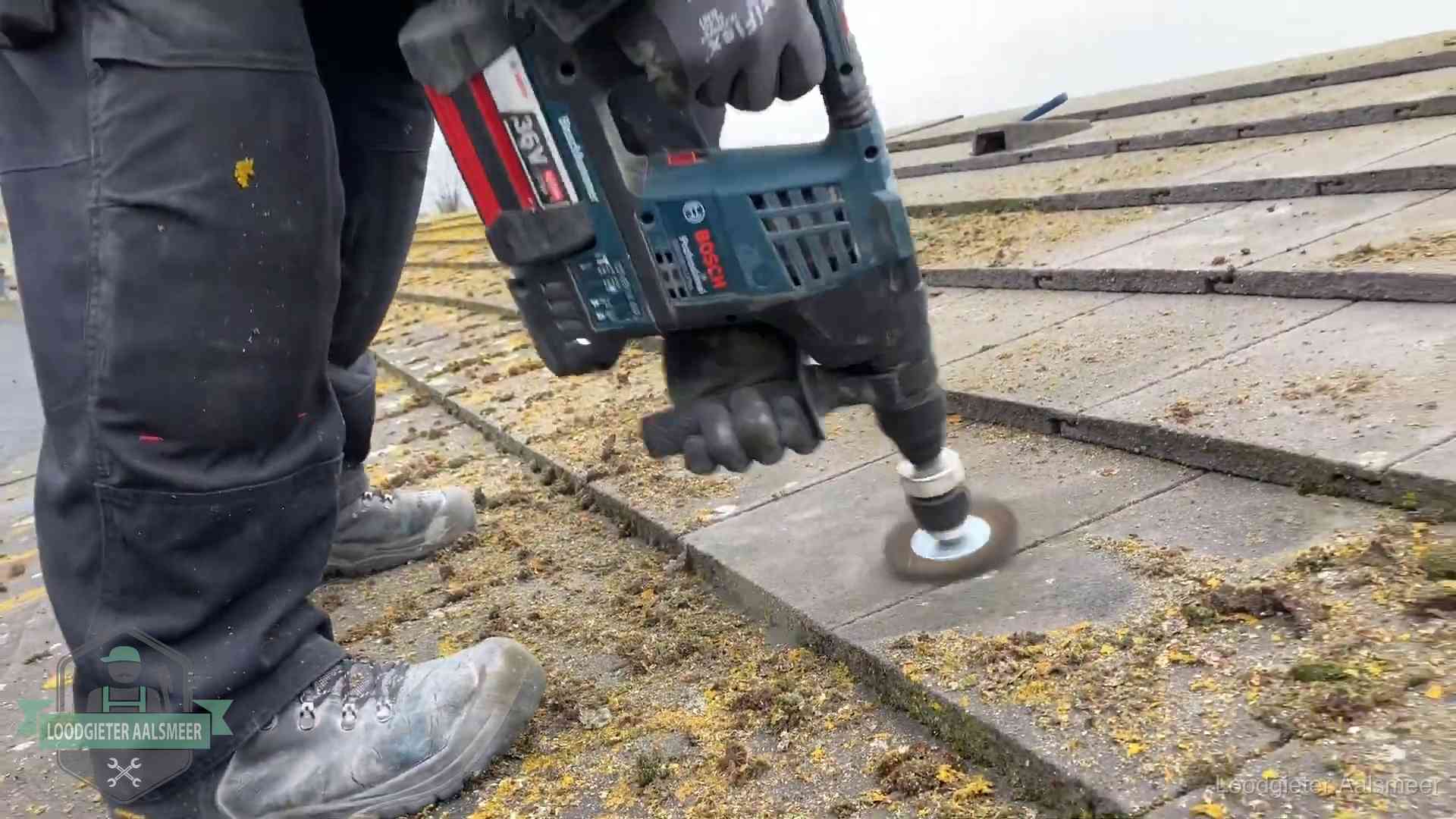 Betonnen dakpannen worden machinaal gereinigd tijdens dakonderhoud in Aalsmeer