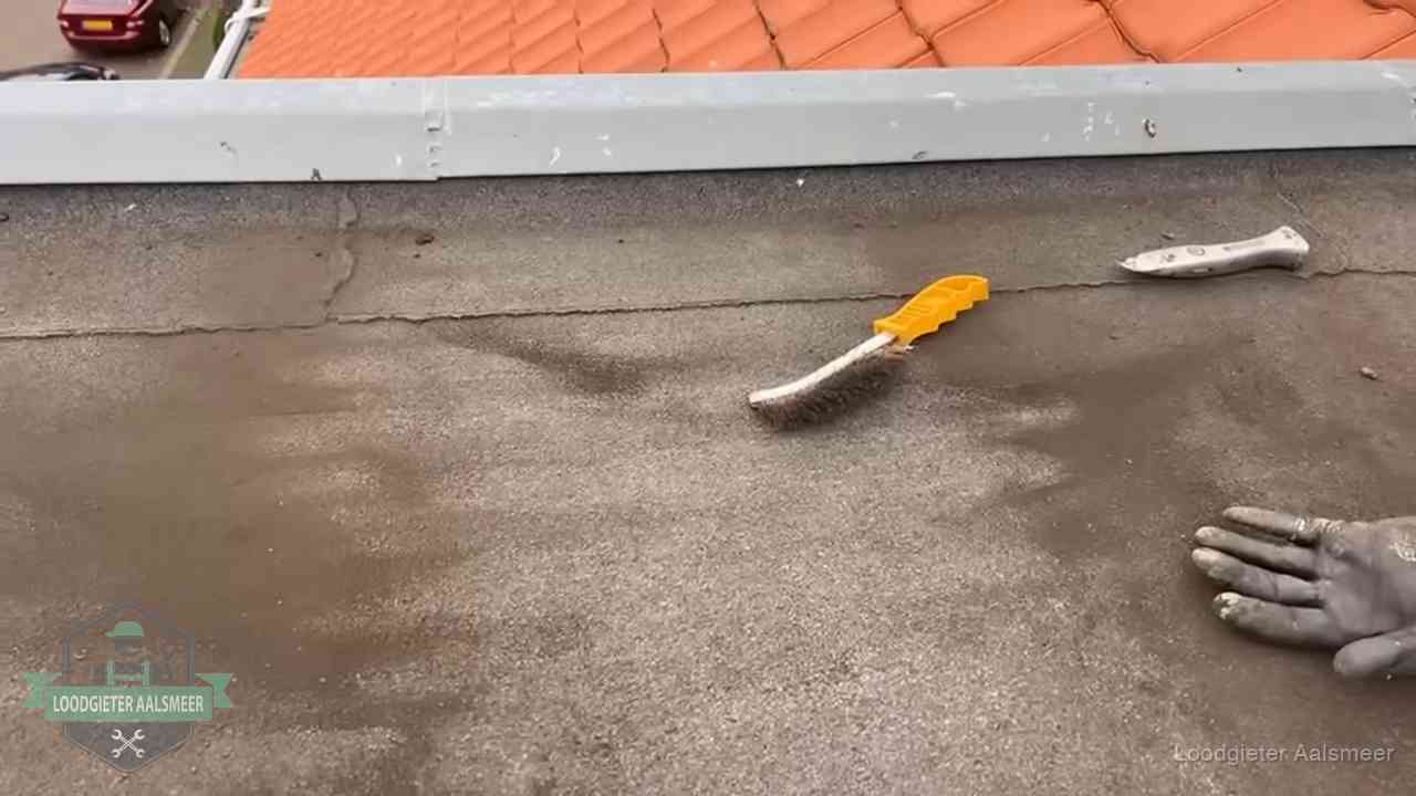 Dakdekker bereidt een bitumen plat dak voor op reparatie bij de daktrim in Aalsmeer