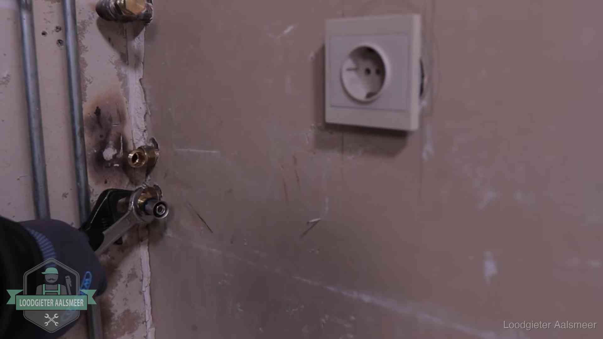 Monteur draait een perskoppeling vast op een leidingaansluiting in Aalsmeer