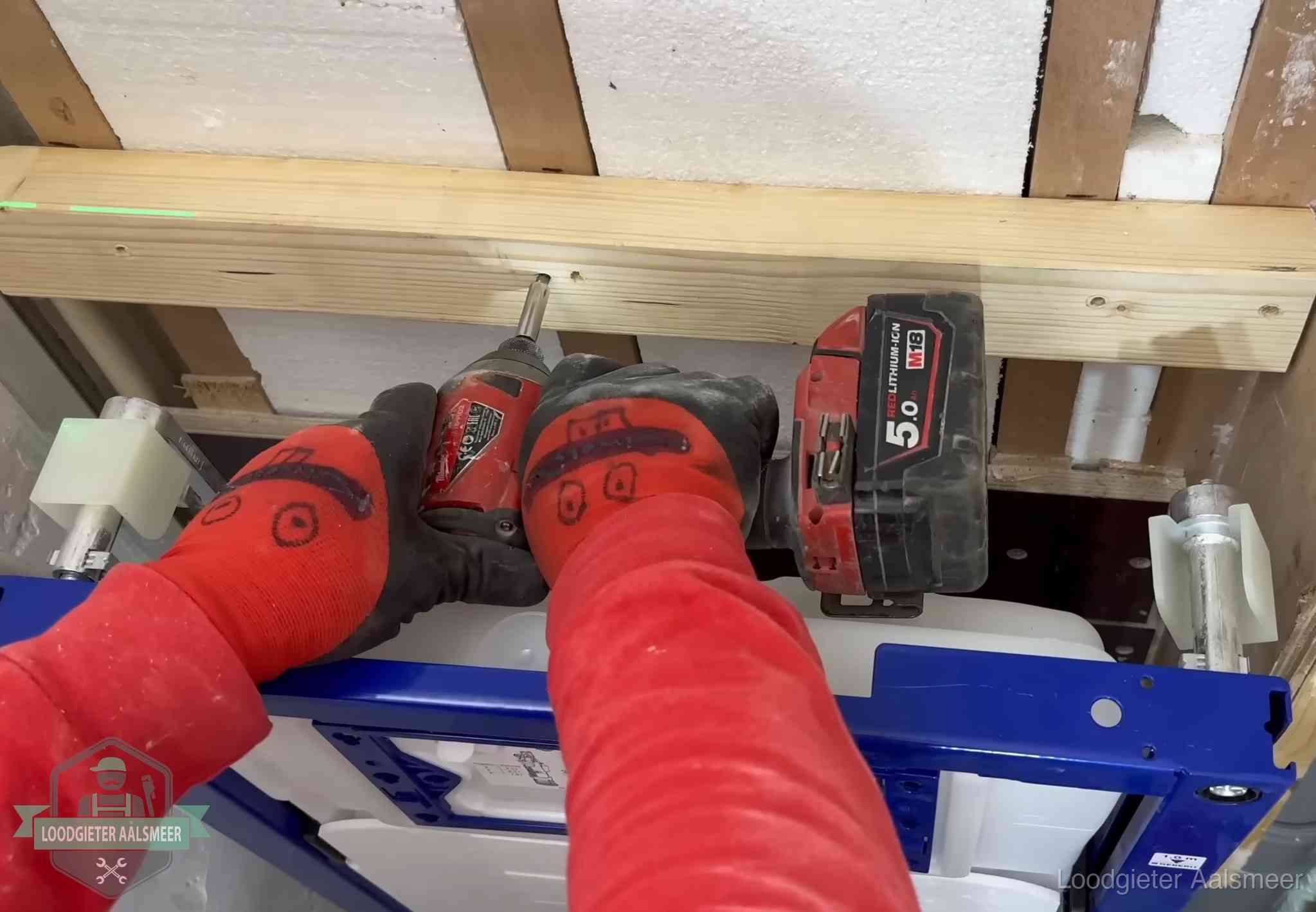 Monteur bevestigt een inbouwreservoir voor een hangend toilet in Aalsmeer