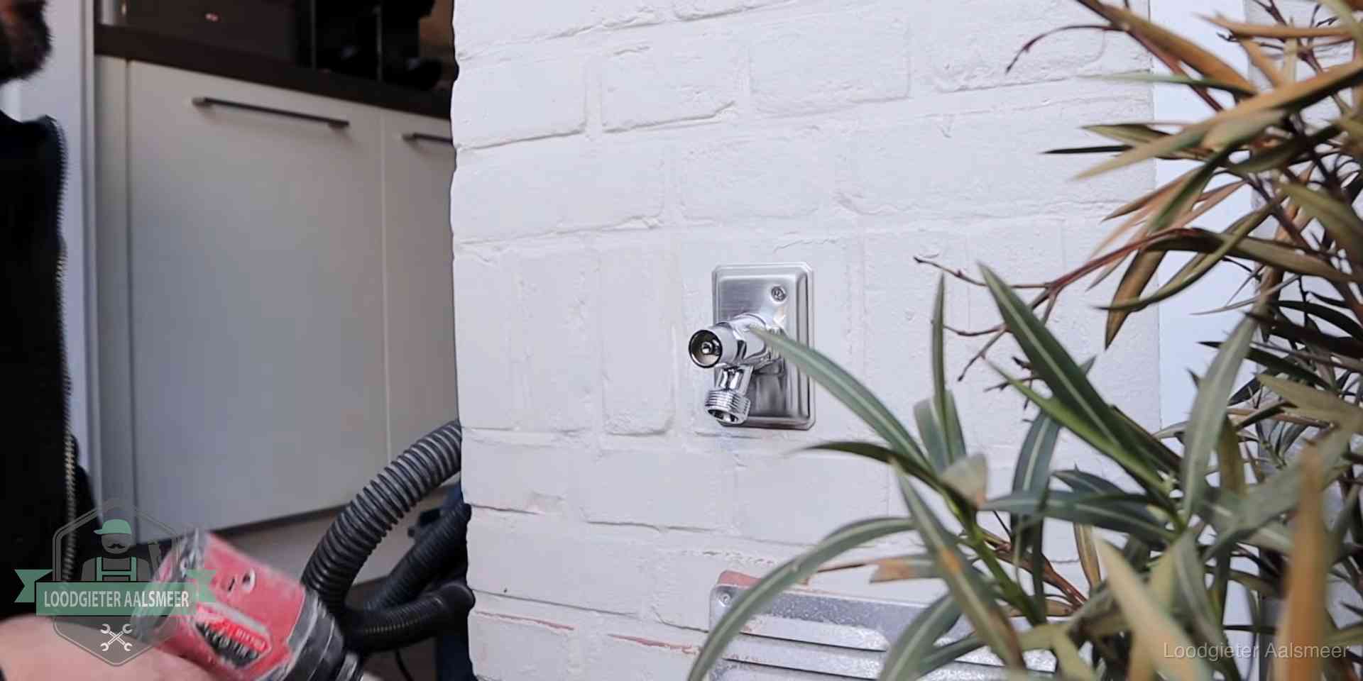 Chromen kraan op een muurplaat bij een woning in Aalsmeer, dichtdraaien is stap een van de lektest