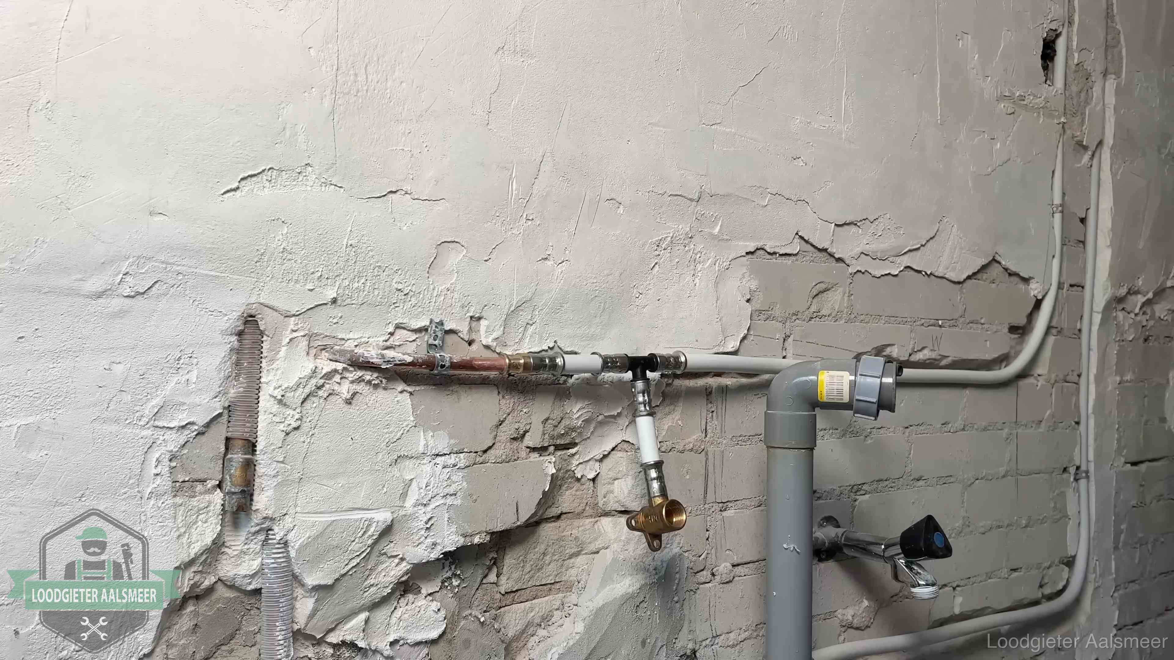 Nieuw leidingwerk naast een oud verroest leidingrestant in een woning in Aalsmeer