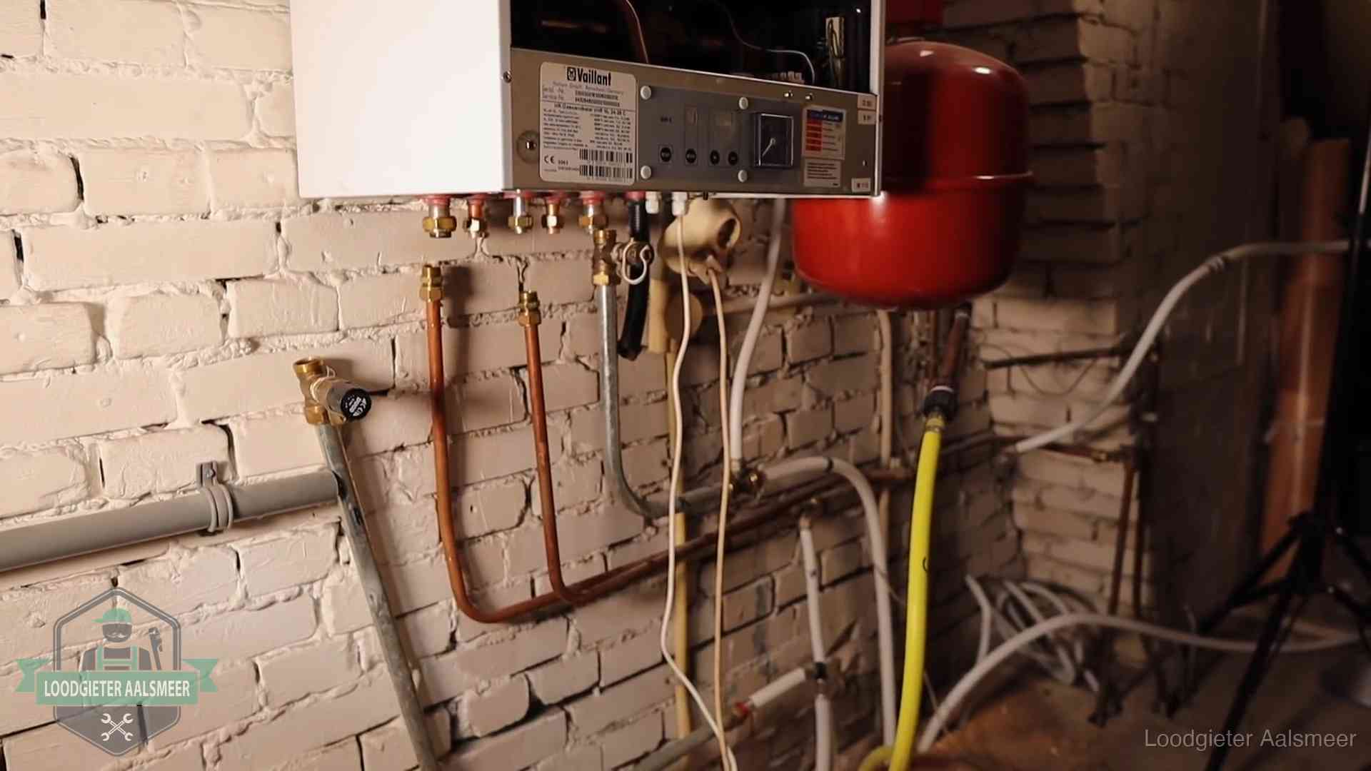 Verouderde cv-ketel met een wirwar van oude leidingen in een woning in Aalsmeer