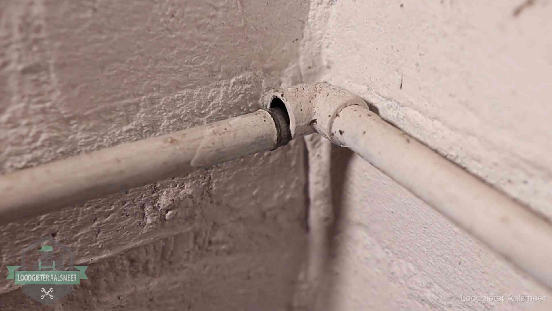 Oude waterleidingen en verborgen lekkage in Aalsmeer Oude geverfde waterleiding met een losliggende fitting in een woning in Aalsmeer