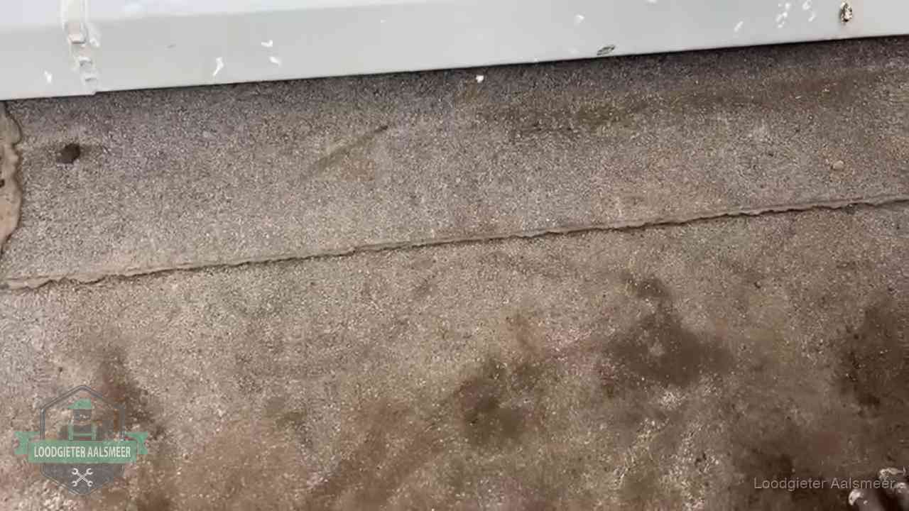 Vochtplekken bij de naad van een plat dak na aanhoudende regen in Aalsmeer
