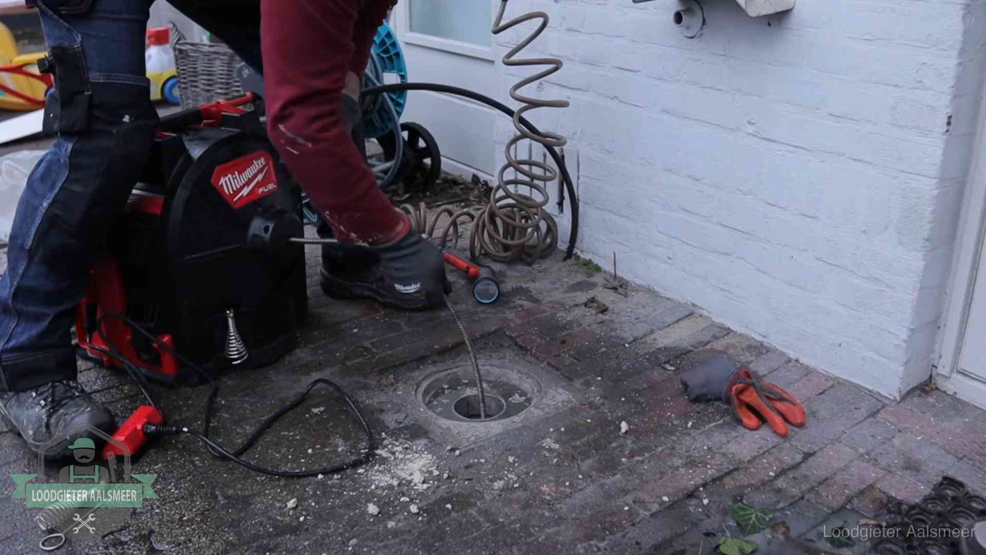 Spiraalmachine bij een ontstoppingsputje in de bestrating in Aalsmeer