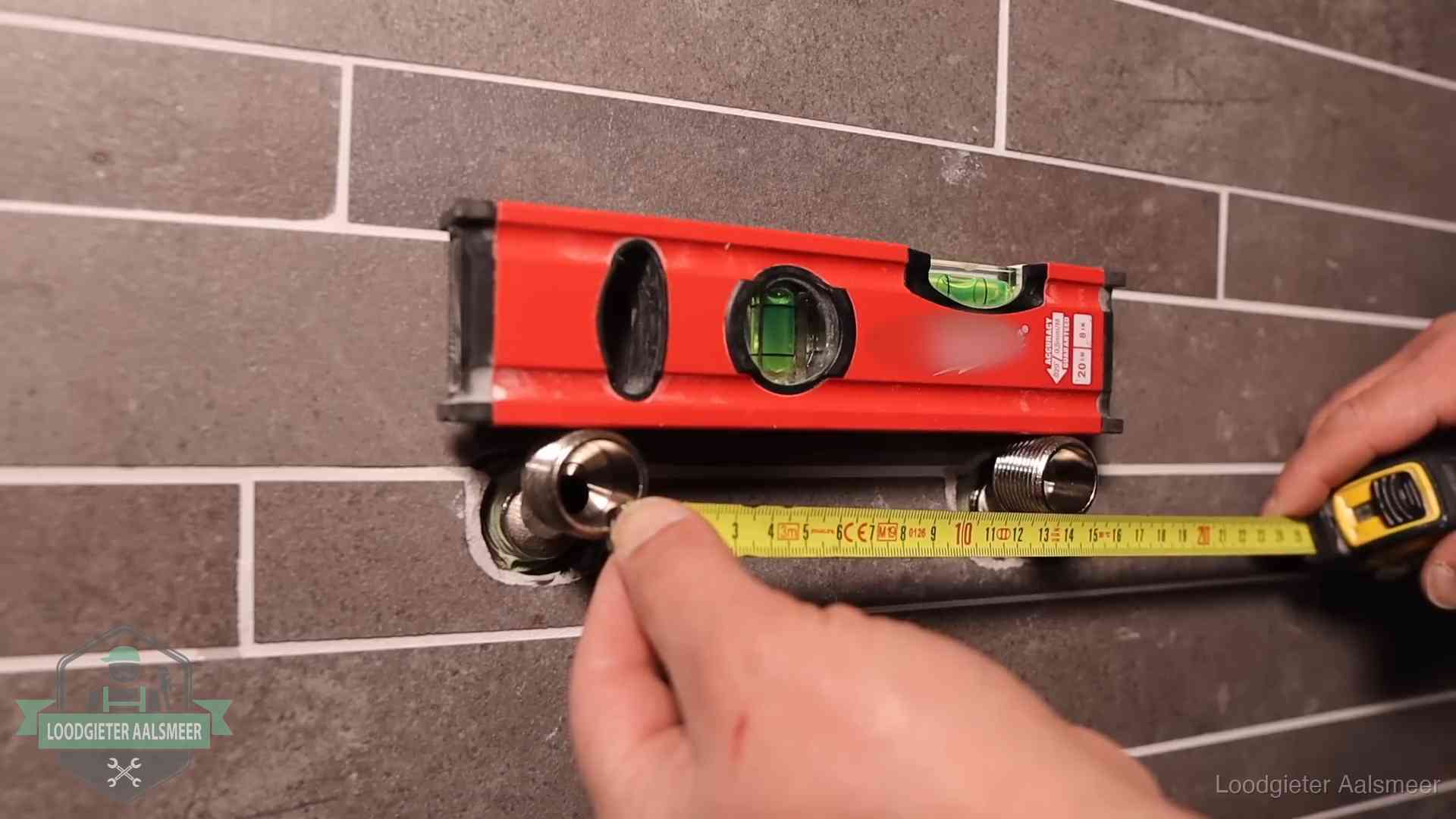 Waterpas en duimstok bij kraan-aansluitpunten in een badkamer in Aalsmeer