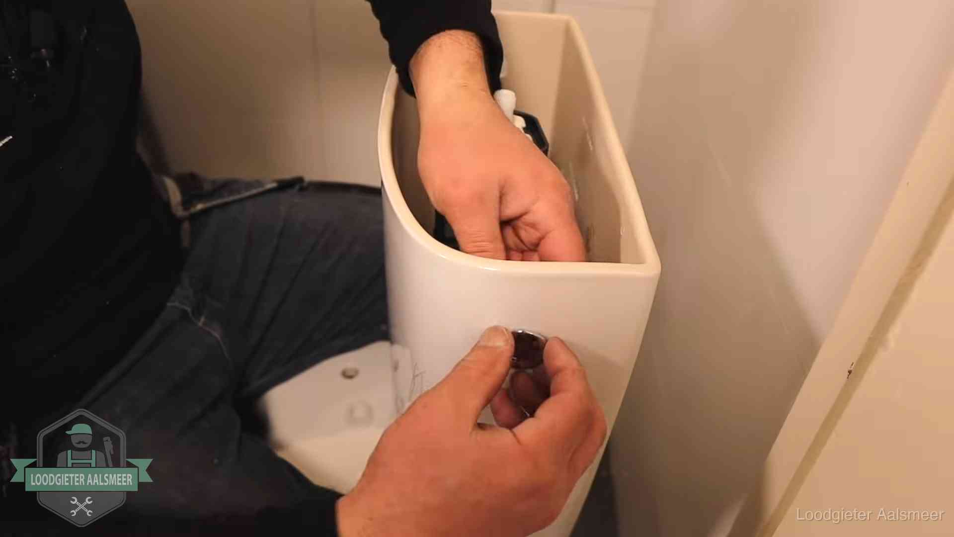 Drukknop van een duoblok-stortbak wordt gemonteerd bij een toilet in Aalsmeer