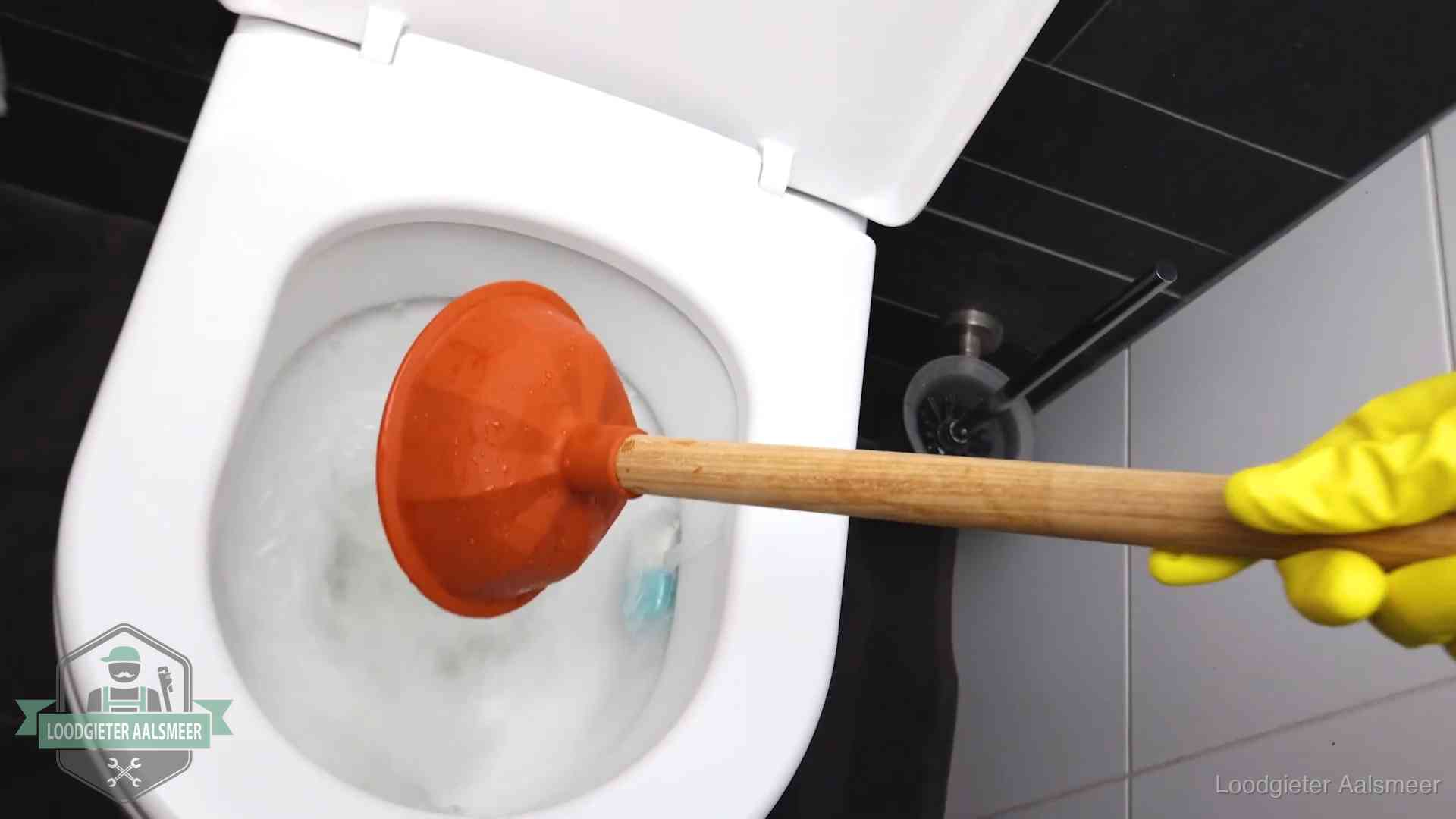 Plopper wordt in de wc-pot gedrukt bij het ontstoppen van een toilet in Aalsmeer