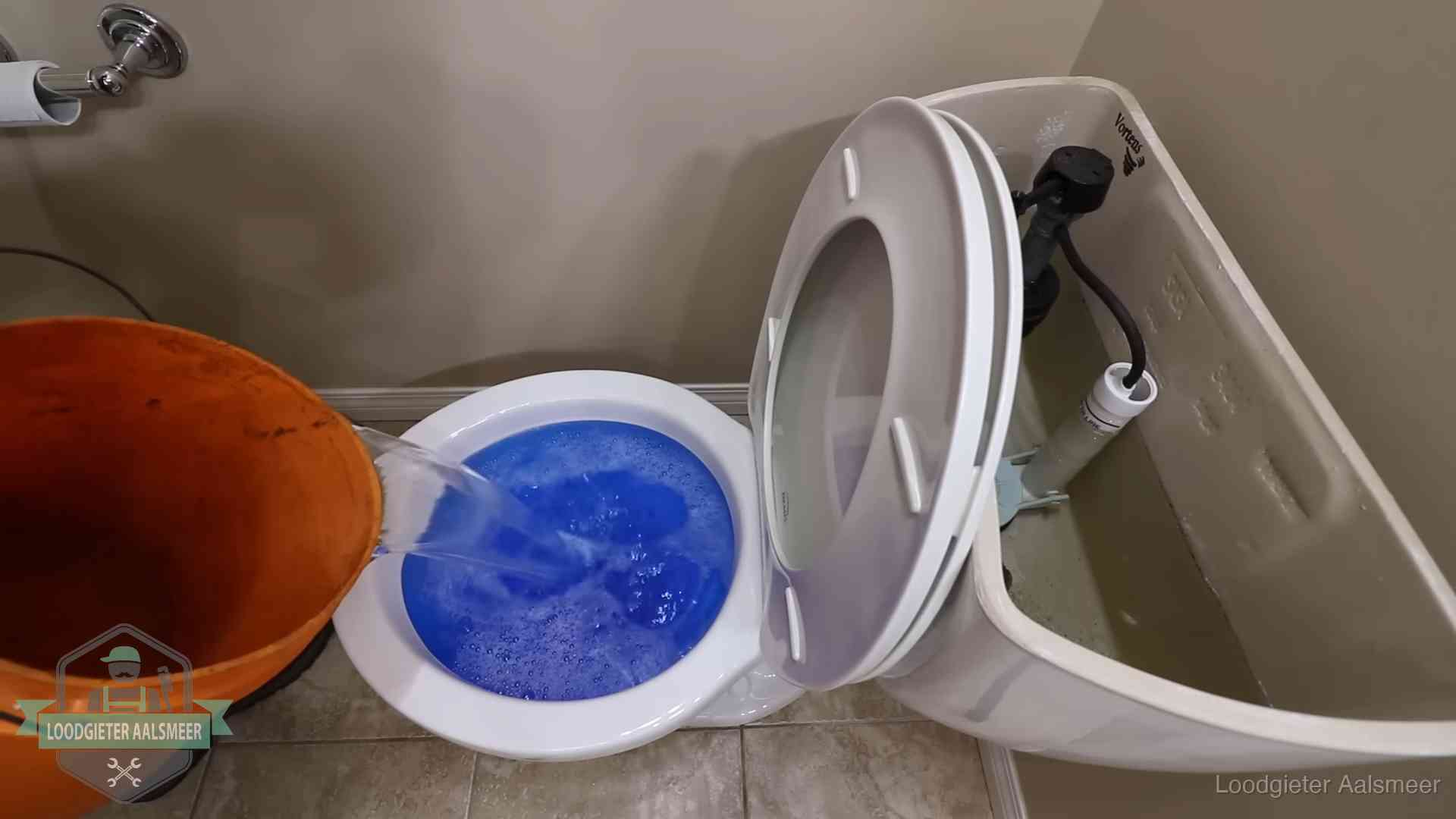 Water bij de wc-pot wordt met een emmer weggewerkt om schade te beperken in Aalsmeer